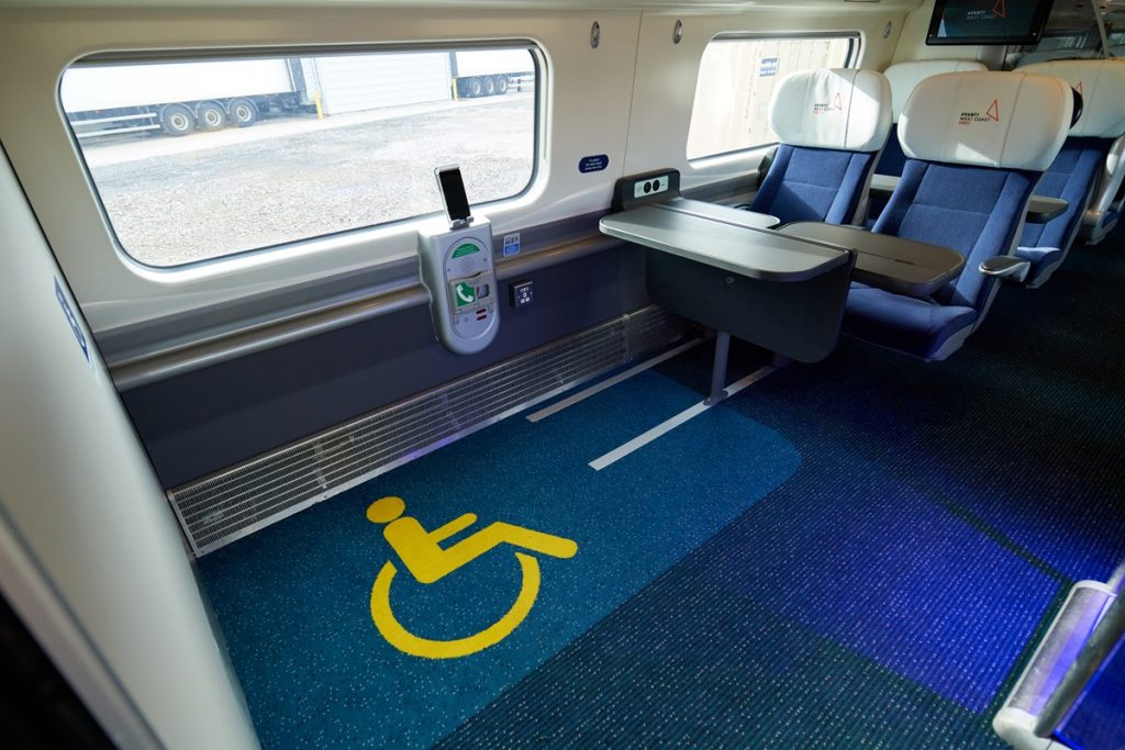 Image shows the refurbished wheelchair space on a Pendolino train, which includes a yellow wheelchair symbol on the carpet.